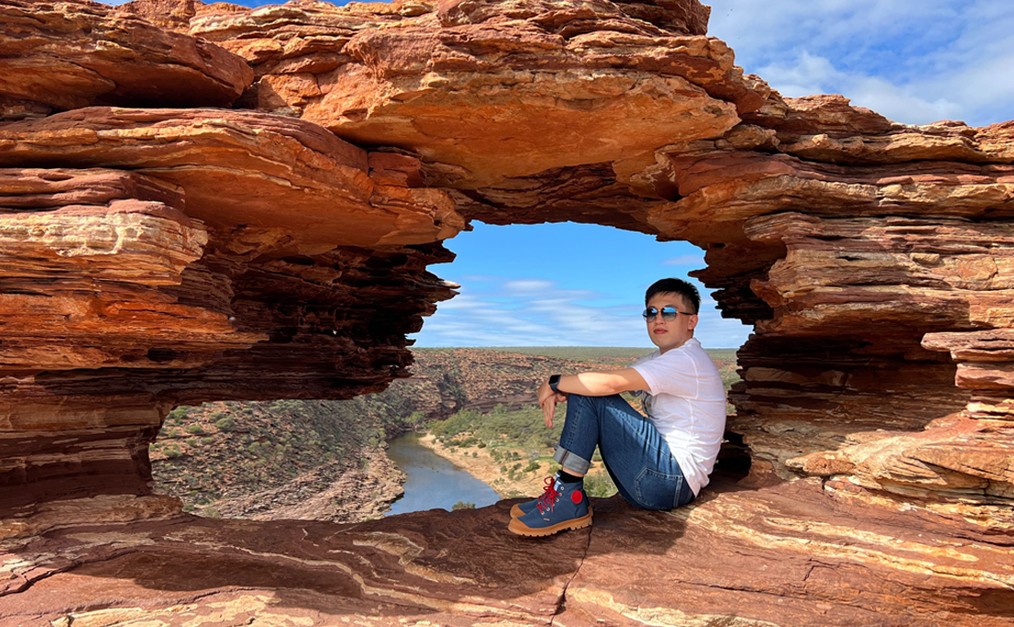 Huanyi pictured sitting inside a rock formation.